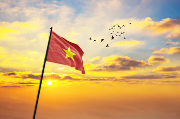 Waving flag of Vietnam against the background of a sunset or sunrise. Vietnam flag for Independence...