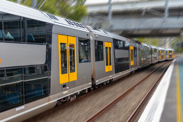 Commuter Train fast moving through a Station in Sydney NSW Australia locomotive electric light rail