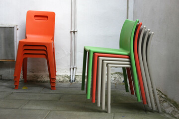Stacked plastic chairs - functional, versatile seating solution. Ideal for events, outdoors, and...