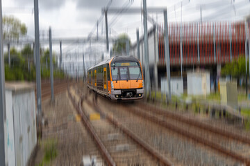 Commuter Train fast moving through a Station in Sydney NSW Australia locomotive electric light rail