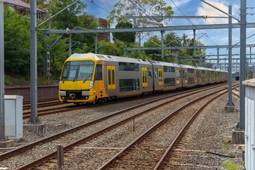 Gartenposter Commuter Train fast moving through a Station in Sydney NSW Australia locomotive electric light rail © Elias Bitar