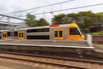 Commuter Train fast moving through a Station in Sydney NSW Australia locomotive electric light rail