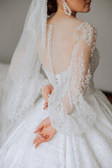 wedding dress with sleeves from the back of the bride. Beautifully knitted dress with fastened buttons.