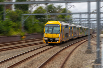 Commuter Train fast moving through a Station in Sydney NSW Australia locomotive electric light rail