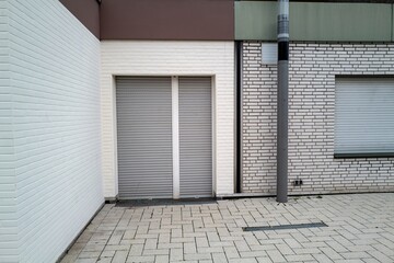 Building with windows and shutters, backyard corner