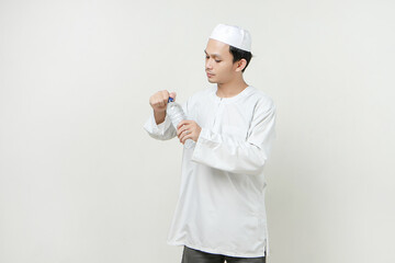 asian muslim man opening water bottle. People religious Islam lifestyle concept. celebration Ramadan and ied Mubarak. on isolated background.