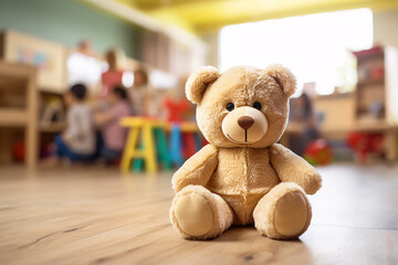Teddy bear with blurry room with children iin children day care center, kindergarten or preschool´in background