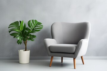 Comfortable armchair, side table and houseplant near light grey wall indoors