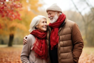 Affectionate senior couple in autumn park, space for text