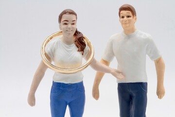 miniature figurines of a couple with a huge wedding golden ring