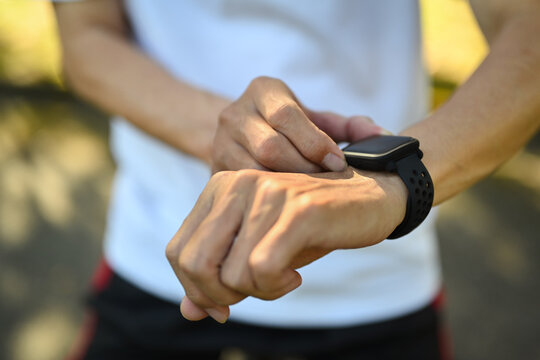 Closeup sporty senior man checking performance or heart rate pulse trace on smartwatch. - Powered by Adobe