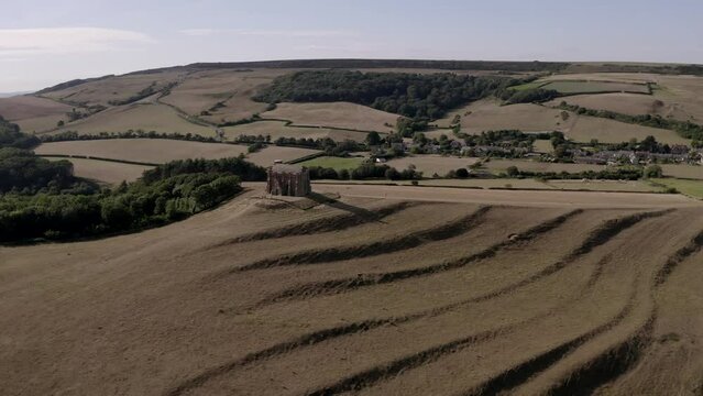 Wide aerial of St Catherine's Chapel, a small limestone chapel situated on a hill above the village of Abbotsbury in Dorset, England showing the surrounding medieval 'strip lynchets' (terraces cut