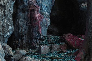a cave with a blue rock. fantasy cave landscape. fantasy nature with dead blue leaves on the...