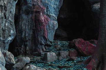 a cave with a blue rock. fantasy cave landscape. fantasy nature with dead blue leaves on the ground. rocky path in fantasy colors. alien environment of rock cave entrance