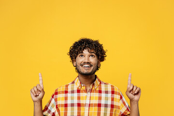 Young happy fun Indian man he wearing shirt casual clothes point index finger overhead on workspace...