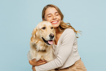 Young smiling happy cheerful owner woman with her best friend retriever wear casual clothes cuddle...