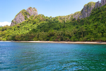 PALAWAN, PHILIPPINES - DECEMBER 21, 2023: Tropical Shimizu Island and paradise beach, El Nido, Palawan, Philippines. Tour A Route. Coral reef and sharp limestone cliffs. 