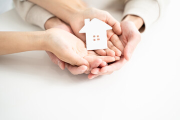 手に収まる家の形をしたペーパークラフト、夫婦の未来設計