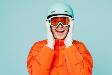 Young smiling fun skier woman she wear warm padded windbreaker jacket hat ski goggles mask helmet...