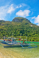 PALAWAN, PHILIPPINES - DECEMBER 21, 2023: Local traditional outrigger tour boat with tropical islands  in El Nido on Palawan Island in the Philippines. 6 million tourists visited Philippines in 2016.
