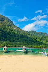 Obraz na płótnie Canvas PALAWAN, PHILIPPINES - DECEMBER 21, 2023: Local traditional outrigger tour boat with tropical islands in El Nido on Palawan Island in the Philippines. 6 million tourists visited Philippines in 2016.