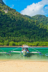 Obraz na płótnie Canvas PALAWAN, PHILIPPINES - DECEMBER 21, 2023: Local traditional outrigger tour boat with tropical islands in El Nido on Palawan Island in the Philippines. 6 million tourists visited Philippines in 2016.