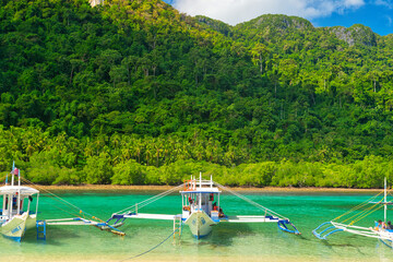 PALAWAN, PHILIPPINES - DECEMBER 21, 2023: Local traditional outrigger tour boat with tropical islands  in El Nido on Palawan Island in the Philippines. 6 million tourists visited Philippines in 2016.
