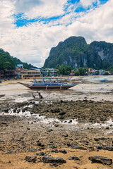 Fototapeta na wymiar PALAWAN, PHILIPPINES - DECEMBER 21, 2023: Local traditional outrigger tour boat with tropical islands in El Nido on Palawan Island in the Philippines. 6 million tourists visited Philippines in 2016.