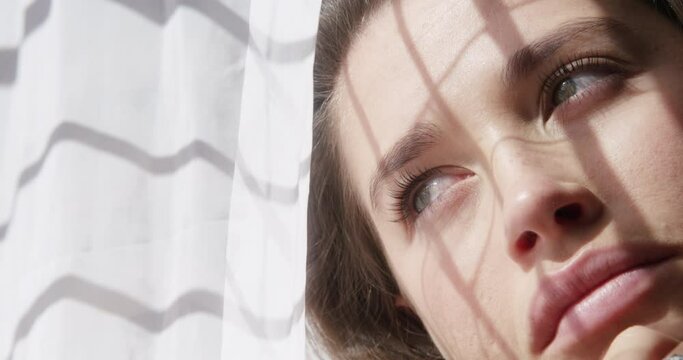 Window, sad woman or thinking of memory with stress, depression or nostalgia in winter in home. Upset face, bored or lonely female person in an apartment to remember past loss, grief or bad history