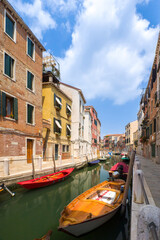 Boats mooring in a channel through quiet Venetian town (Venice, Italy)