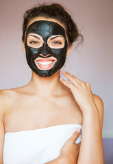 Young woman with a mask for the face of the therapeutic black mud