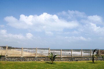Wooden fence with beach waves and blue sky in the background at Mahabalipuram, Tamilnadu.
