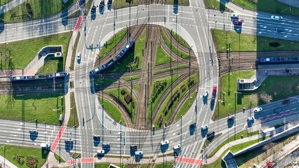 Traffic circle Rondo Czyzynskie in Krakow, Poland, with tramway crossing, four trams, three lane city roads, bicycle lanes, underground pedestrian crossings and cars. Aerial view from above 