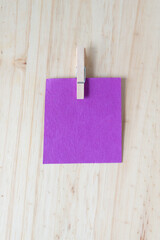 blank purple note paper with clothespin on wood