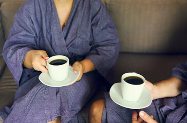 Loving couple in bathrobe drinking coffee in the morning