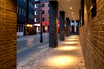 Illuminated and covered walkway in the city centre of Düsseldorf at night.