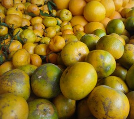 Stacks of orange fruits of various types and sizes with sweet and sour tastes are sold in fruit stores