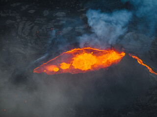 Awesome close up view of boiling red lava lake inside the active volcano crater, drone top down...