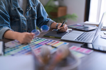 Graphic designer women working on digital tablet and laptop to designing brand logo graphic design
