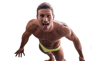 Shirtless muscular man shot from above, looking at camera, standing isolated in studio shot