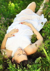 Fototapeta premium Beautiful pregnant woman relaxing on grass