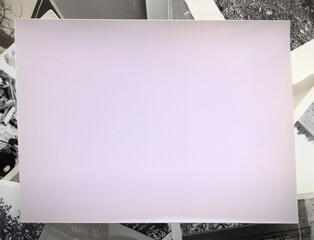 Unused photo paper against the background of old black and white photographs
