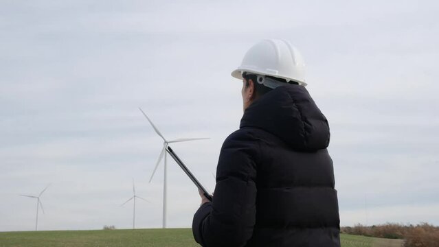 n a helmet, a female engineer confidently stands, using a digital tablet to control a wind turbine. This image not only promotes labor equity but also highlights the significant contributions of women