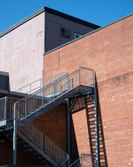 A steel staircase on a red brick wall