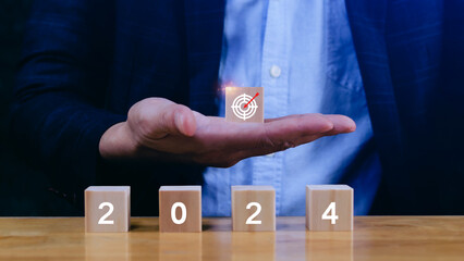 Hand arranging wood block stacking with business strategy and Action plan, targeting the business concept. Business development concept. 2024 Goal plan action.