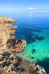 The most beautiful Apulian coast in Italy: Cala Corvino. Typical coastline near Monopoli : high and rocky coast characterized by small sandy coves with cliffs, rocky arches and sea caves. - obrazy, fototapety, plakaty