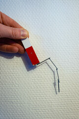 Iron nails hang from a magnet. Used for demonstration in physics class.