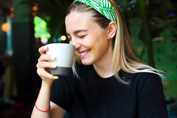 Cheerful woman enjoying coffee in cafe