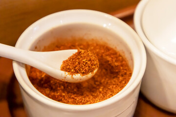 Red chili powder in a white cup for cooking
