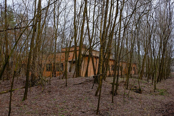Bare trees surround an isolated, unmarked building.